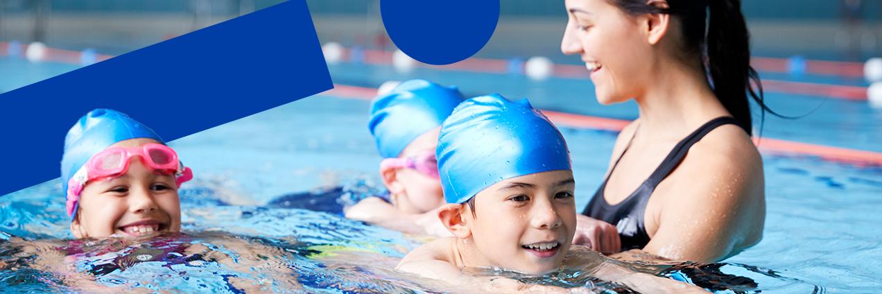 Profesora de natación enseñando a nadar a tres alumnas